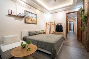 a bedroom with a bed and a table and a couch at Homestay Nhacuabu in Hanoi