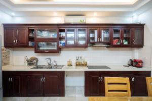 a kitchen with wooden cabinets and a sink at Homestay Nhacuabu in Hanoi