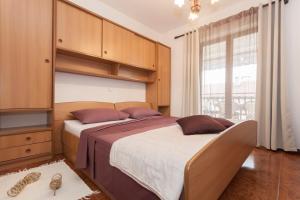 a bedroom with two beds and a large window at Apartmani Villa Gordana in Pula