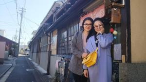 two women standing next to each other on a street at Nostalgic guesthouse for 1 to 2 Females shared toilet and shower in Kyoto