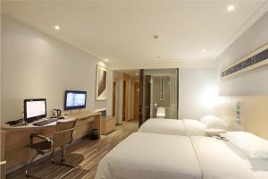 a hotel room with two beds and a desk with a computer at City Comfort Inn Guiyang North High Speed Railway Station in Guiyang