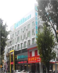 ein großes weißes Gebäude an einer Stadtstraße in der Unterkunft City Comfort Inn Huizhou Huiyang High-speed Railway Station in Huizhou