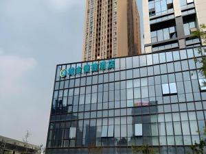 un bâtiment en verre avec un panneau en haut dans l'établissement City Comfort Inn Hefei Mingzhu Square Fanhua Avenue, à Hefei