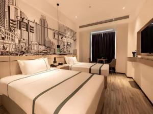 two beds in a hotel room with black and white at City Comfort Inn Hefei Mingzhu Square Fanhua Avenue in Hefei