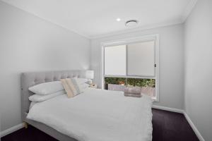 沃加沃加'Lumeah' - Apartment 1 Central Wagga的一间白色的卧室，配有一张白色的床和一扇窗户