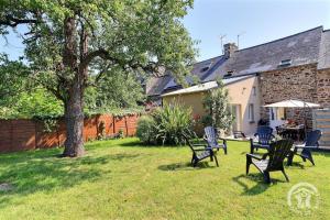 a yard with chairs and a table and a tree at Laliroz in Roz-Landrieux