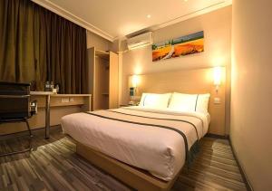 a hotel room with a large bed and a desk at City Comfort Inn Yulin Walking Street in Yulin +131 photos