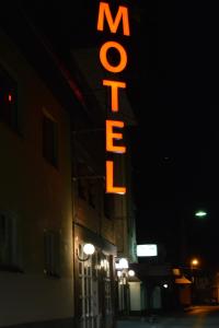 a neon sign on the side of a building at night at Motel Luxor in Visoko