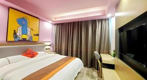 a bedroom with a bed and a desk and a tv at Jun Hotel Hubei Wuhan Jianghan District Jianghan Road Walking Street in Wuhan