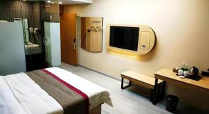 Cette chambre dispose d'un lit et d'une télévision murale. dans l'établissement Thank Inn Hotel Sichuan Nanchong Gaoping District Longmen, à Gaoping 36 autres photos