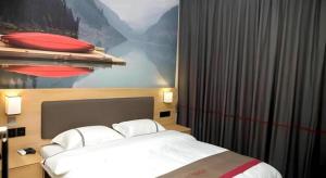 un lit dans une chambre d'hôtel avec un tableau sur le mur dans l'établissement Thank Inn Hotel Jiangsu Wuxi Jiangyin District Ligang Street Xinggang Road, à Jiaoxi 47 autres photos