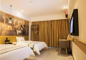 a hotel room with two beds and a flat screen tv at City Comfort Inn Maoming Xinyi Donghuicheng in Xinyi