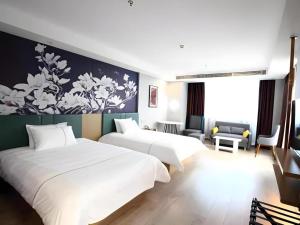 a hotel room with two beds and a couch at Magnotel Nanjing Lishui Baota Bei Road in Lishui