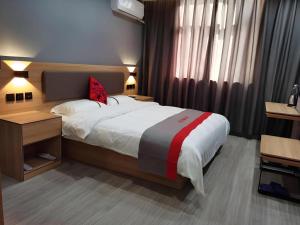 a bedroom with a large bed and a desk at Jun Hotel Henan Sanmenxia Dennis Plaza in Sanmenxia
