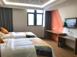 a hotel room with two beds and a flat screen tv at Shell Hotel Shanghai Minhang District Wenjing Road Metro Station in Shanghai