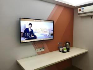 a flat screen tv hanging on a wall at Shell Hotel Shanghai Minhang District Wenjing Road Metro Station in Shanghai
