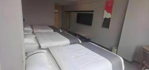 une rangée de lits vides dans une pièce dans l'établissement Thank Inn Hotel Guangxi Qinzhou Lingshan Renhe, à Lingshan