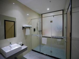 a bathroom with a glass shower and a sink at Green Tree Inn Express Tangshan Yueting County Bus Station in Laoting +82 photos