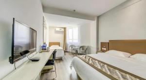 a hotel room with two beds and a flat screen tv at GreenTree Alliance Hotel Qinghuangdao Wanda Plaza in Qinhuangdao