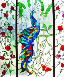 a painting of a peacock in a stained glass window at Hostal de Las Américas in Oaxaca City