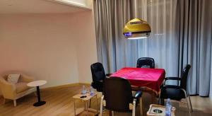 a living room with a table with chairs and a yellow ceiling at GreenTree Inn Hubei Yangxin County Lianhua Lake Mingyue Bay in Yangxin +24 photos
