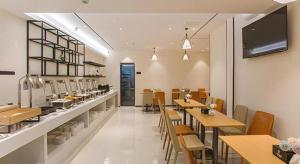a dining room with tables and chairs in a restaurant at City Comfort Inn Wuzhou Sun Plaza Wanda in Wuzhou
