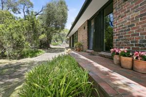 a brick building with potted plants on a patio at Blairgowrie Beach Bungalow - Pet & Value Stay in Blairgowrie