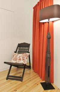 a chair with a pillow and a lamp in a room at Aldeia do Priolo in Nordeste
