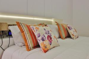 a white bed with several pillows on it at Aldeia do Priolo in Nordeste