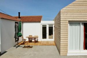 a wooden house with a patio and a table at Aldeia do Priolo in Nordeste