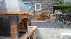 a backyard with a pizza oven and a table at Aldeia do Priolo in Nordeste