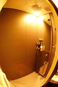 a bathroom with a shower with a round mirror at Hotel Miyoshino Annex in Sano