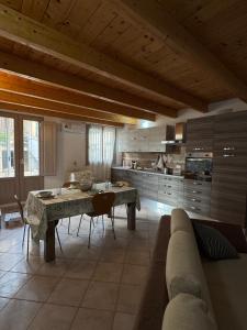 a large kitchen with a table and a couch at Da Nonnu in Teulada