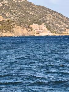 a large body of water with a large building on a hill at Da Nonnu in Teulada +21 photos
