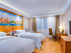 Giường trong phòng chung tại Vienna Hotel Shanghai Hongqiao National Exhibition Cente Sijing Metro Station