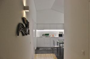 a kitchen and dining room with white cabinets and a table at Aldeia do Priolo in Nordeste