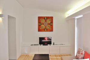 a living room with a tv on a white wall at Aldeia do Priolo in Nordeste