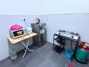 a small kitchen with a microwave and a stove at Friendly Homestay Malacca in Melaka +12 photos