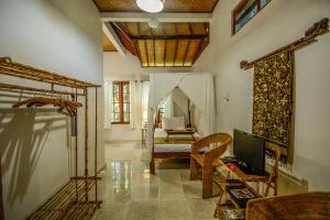 a living room with a bed and a tv in a room at Aashaya Jasri Resort in Jasri