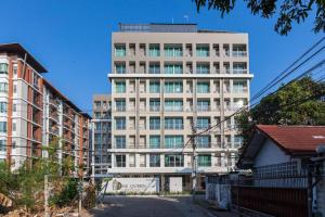 a tall white building with a lot of windows at The Queen Palace in Ban Bang Talat