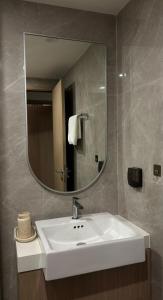 a bathroom with a white sink and a mirror at Denzi home in Ho Chi Minh City