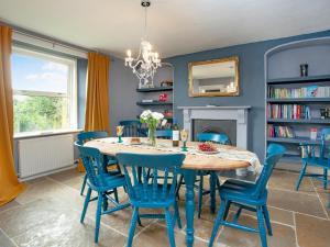 a dining room with a table and chairs and a fireplace at Uk45542-The Farm House in Sticklepath