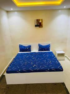a bed with blue pillows in a room at AF Logement in Dakan