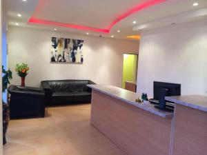 a lobby with a black leather couch and a bar at Meerbuscher Hof in Meerbusch