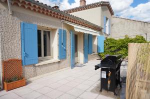 ヴェゾン・ラ・ロメーヌにあるGite : L'Art de Vivreの青いシャッターとゴミ箱のある家