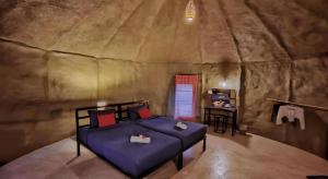 a bedroom in a cave with a bed and a desk at Avartarn Miracles Hotel in Ban Soi Rakhlong +68 photos