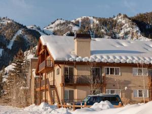 a house with a truck parked in the snow at Crestview Condo 25 in Ketchum