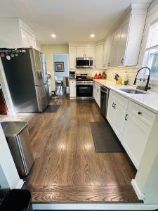 a kitchen with white cabinets and a stainless steel refrigerator at The Soft Landing Elle's Home Near NYC in Trenton