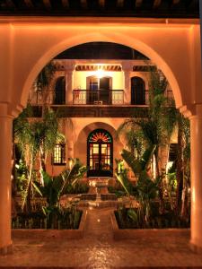 an archway in a building with a courtyard with plants at Al Fassia Aguedal in Marrakech