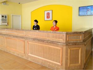 dos mujeres de pie en un mostrador de recepción en una sala de espera en Home Inn Tianjin Weidi Avenue Culture Centre en Tianjin